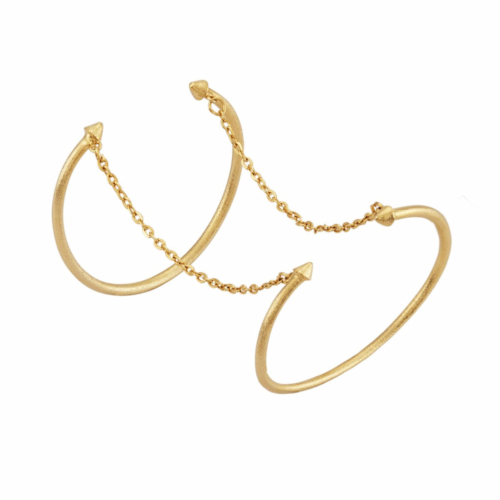 A flexible arm cuff bracelet with a gold and silver finish, featuring a textured handcrafted design.